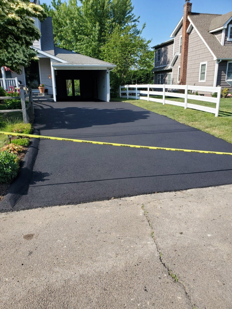 New Black Asphalt Driveway and Yellow Caution Tape
